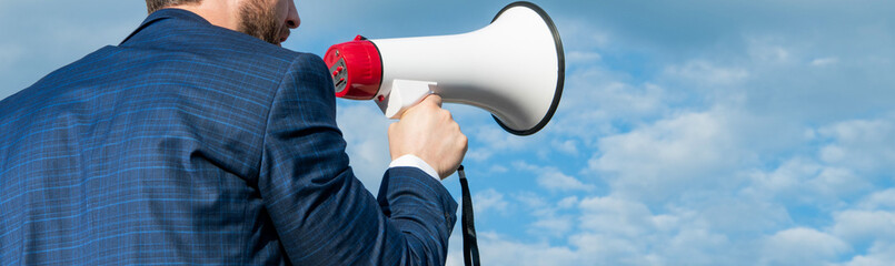 back cropped view of businessman shout in loudspeaker on sky background