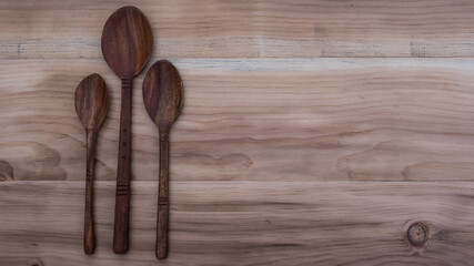 Three wooden spoons head on a wooden background. wooden utensils. wooden spoon
