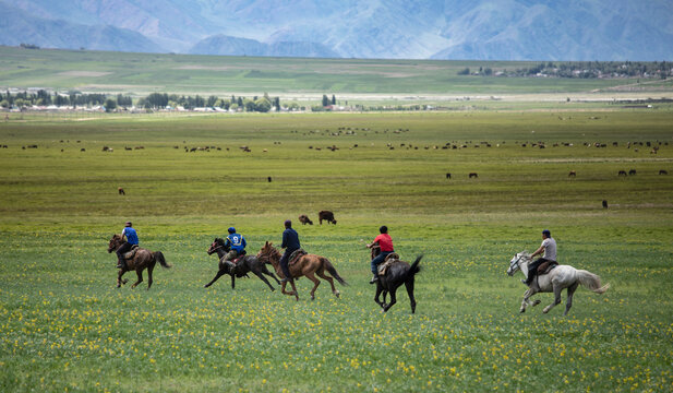 Men riding horseback during a game of Kok Boru in rural Kyrgyzstan.