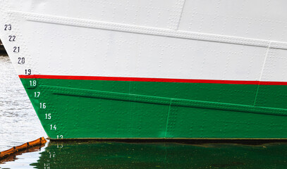 Sailing yacht hull with red waterline and draft marks