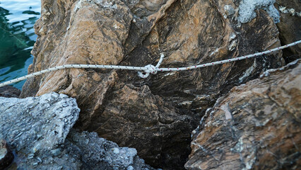 tying a boat with a rope. the boat moored at the shore.