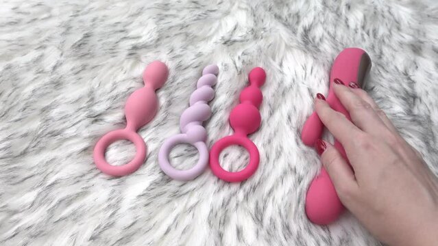 woman hand and sex toys on fur background 