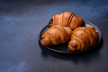 Crispy chocolate croissant with Christmas decorations on wooden cutting board