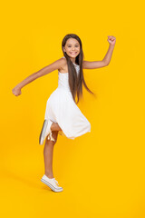 Fototapeta na wymiar cute teen girl in white dress running on yellow background