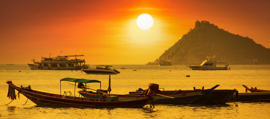 Naklejka na ściany i meble Sunset on Koh Tao Island. Traditional boats and tropical island landscape. Thailand's famous travel and holiday island. 