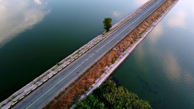Beautiful country road in the middle of a calm lake