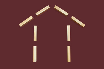 House shape from wooden rectangles on a brown background. The concept of building or buying your...