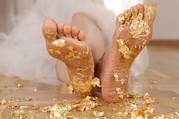 Golden glitters on female bare feet. Enjoy life , Shine and Sparkle concept.