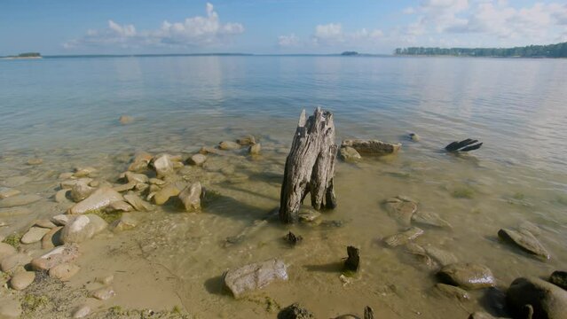 The calm blue waters of Sam Rayburn Reservoir gently lap the rocky shore revealing the low lake levels that is usually under water.