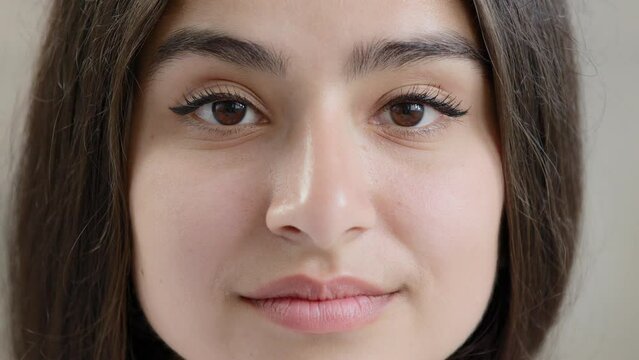 Close up female body part human young face sensual sexy arabic islamic attractive beautiful girl model lady gorgeous woman with black eyeliner on dark eyes natural daily makeup stare looking at camera