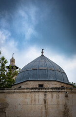 Fototapeta na wymiar dome covered with lead sheet. Ramazanoglu Medresesi and Ulucami. Great Mosque Ulucami minaret in the background. Adana, Turkey