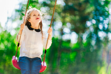 Little  girl swinging on a swing outdoors in the park