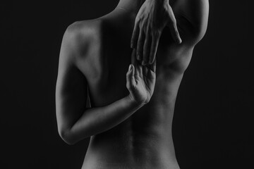 girl's back close-up on a dark background, the concept of treatment of the spine and back