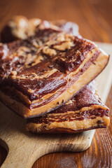 Whole smoked bacon on cutting board.