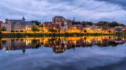 Fototapeta na wymiar Downtown Augusta at Riverfront - A wide-angle view of Downtown Augusta at shore of Kennebec River on a stormy Autumn evening. Maine, USA.