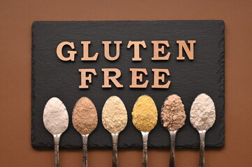 Gluten free text and spoons of various gluten free flour. Flat lay, top