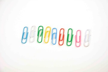 Colored paper clips on a white background.