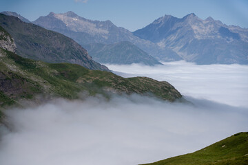 mountain plateau and valley with cloud filling the valley below and clear blue summer sky