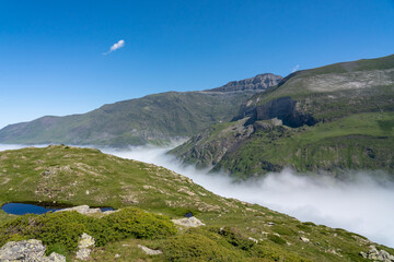 mountain plateau, grass meadow, lakes and valley with cloud filling the valley below and bright...