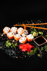 close up of sushi rolls on black tray