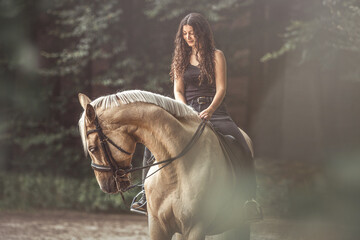 Portrait of a young woman and her stunning palomino kinsky horse. Female equestrian and her horse - obrazy, fototapety, plakaty