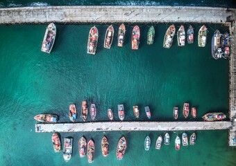 Aerial drone shot of many fishing boats in Kalk Bay harbour, near Cape Town, South Africa