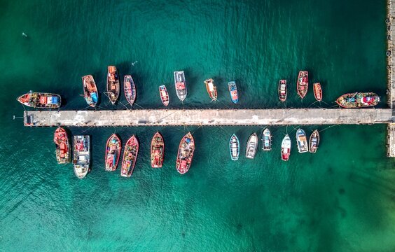 Aerial drone shot of many fishing boats in Kalk Bay harbour, near Cape Town, South Africa