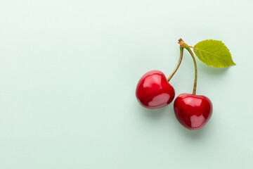 Cherry berries on a pastel background top view.  Background with a cherry on a sprig, flat lay