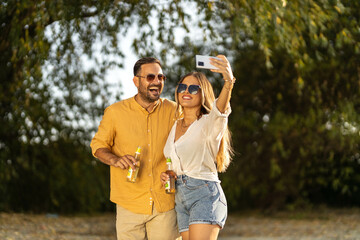 Couple having fun outdoors and taking selfies, summer time stock photo