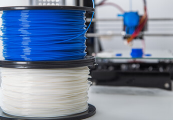 Personal 3d printer and abs or pla filament coils next to him. - 522120492