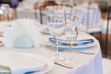 empty wine glasses on a round table with a white tablecloth. 