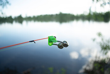 bell alarm is on fishing rod spinning in nature bells of allure are attached to the end of the...