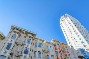 Low-rise apartment buildings beside the high-rise building in a low angle view at San Francisco, CA