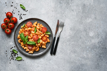 Pasta with tomato sauce and cherry tomatoes on a concrete background, top view, with space for text