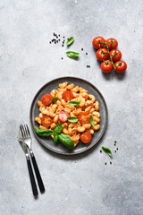 Pasta with tomato sauce and cherry tomatoes on a concrete background, top view, with space for text