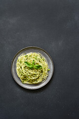 Pasta with pesto sauce. Spaghetti with green sauce, basil and garlic top view.