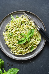 Pasta with pesto sauce. Spaghetti with green sauce, basil and garlic top view.