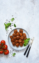 Meatballs with tomato sauce and basil in a plate, top view with space for text