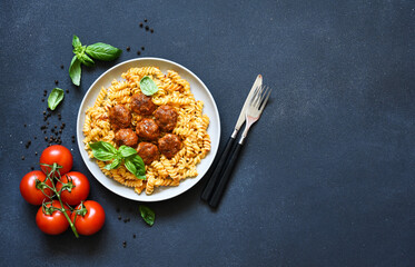 Italian pasta with meatballs, tomato sauce and spices, top view, with space for text