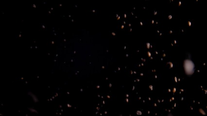 Fragrant coffee seeds raising in super slow motion. Aromatic beans flying up.