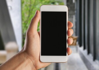 Human hand holding phone with blank screen