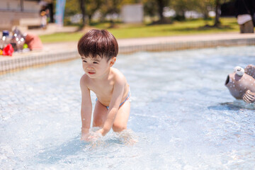 プールで水遊びをする男の子