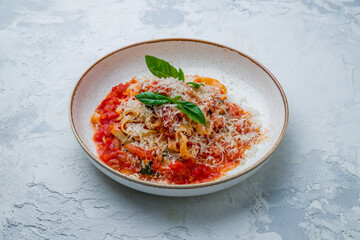 Pomodoro fettuccine with tomatoes on plate on white concrete table