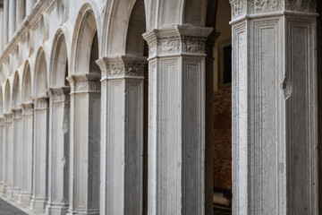 A repetitive architecture of Venetian Gothic columns in muted day light.