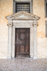 An old, weathered wooden door with an artistic frame in Venice.