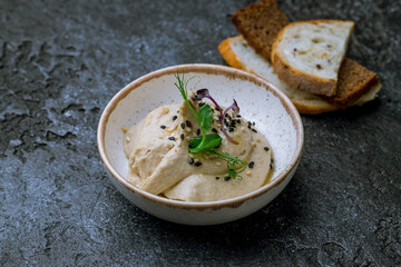Traditional homemade hummus with fried croutons on dark stone table