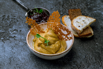 The chicken liver pate with bread and jam on dark stone table