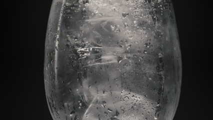 Ice water bubbling inside glass closeup. Cocktails and beverages concept
