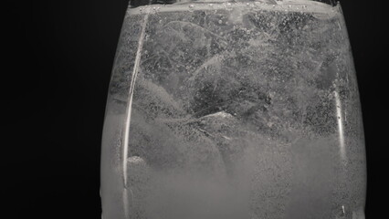 Ice cube bubbled water glass closeup. Refreshing tonic cocktail concept