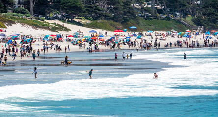 Fototapeta premium Large numbers of people enjoy the Pacific Coast of California at the dog friendly Carmel Beach, at Carmel by the Sea. 